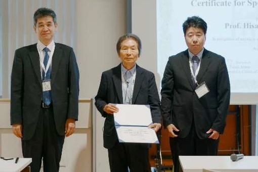 iWEM 2026 表彰式で賞状を手にする中野久松 名誉教授